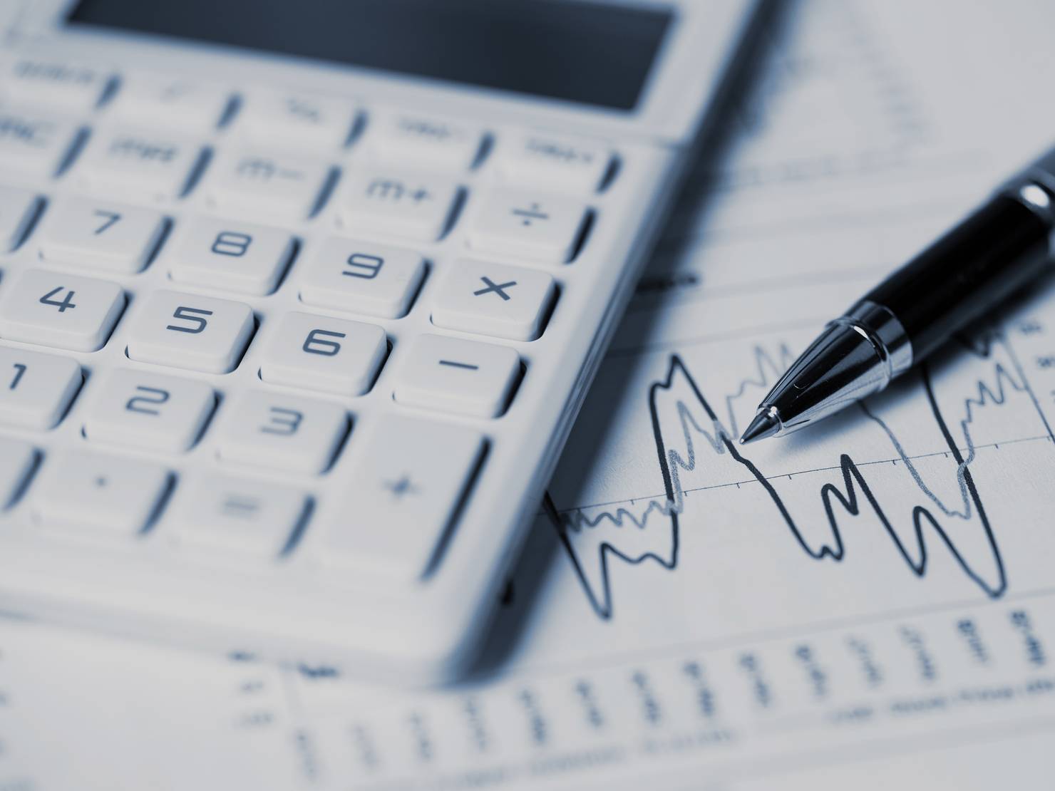 Close-up of calculator, pen and charts