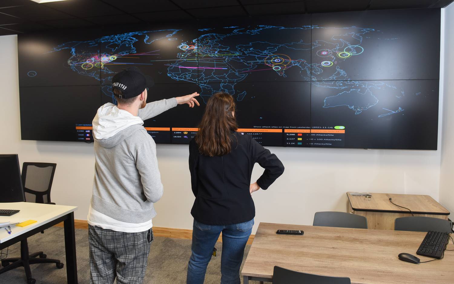 Two students looking at a large TV screen