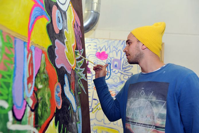 A student standing and painting