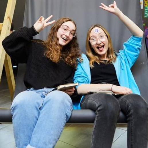 Two students sitting on a large deck chair