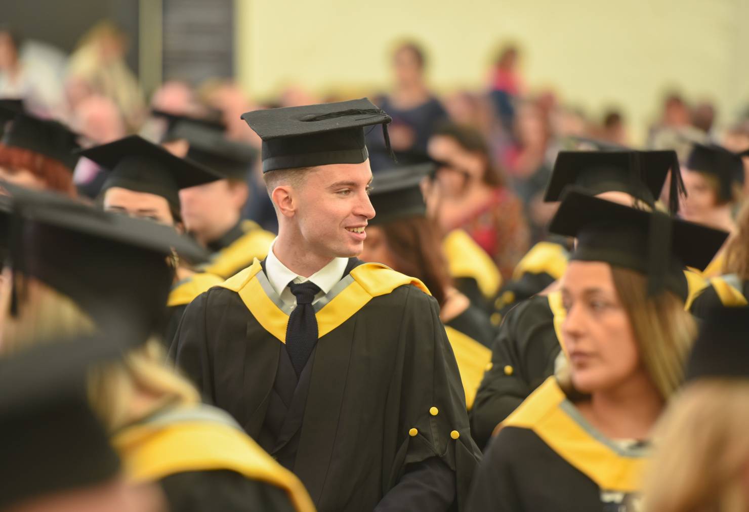 A student sitting with their peers in a graduation ceremony