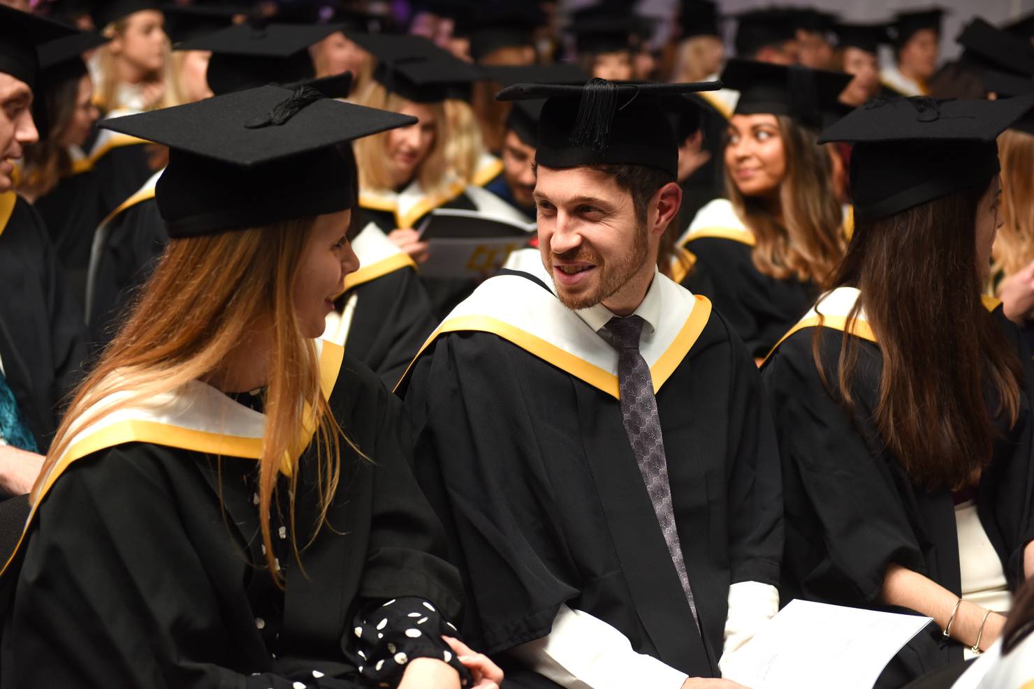 Two students looking at each other in a graduation cermony