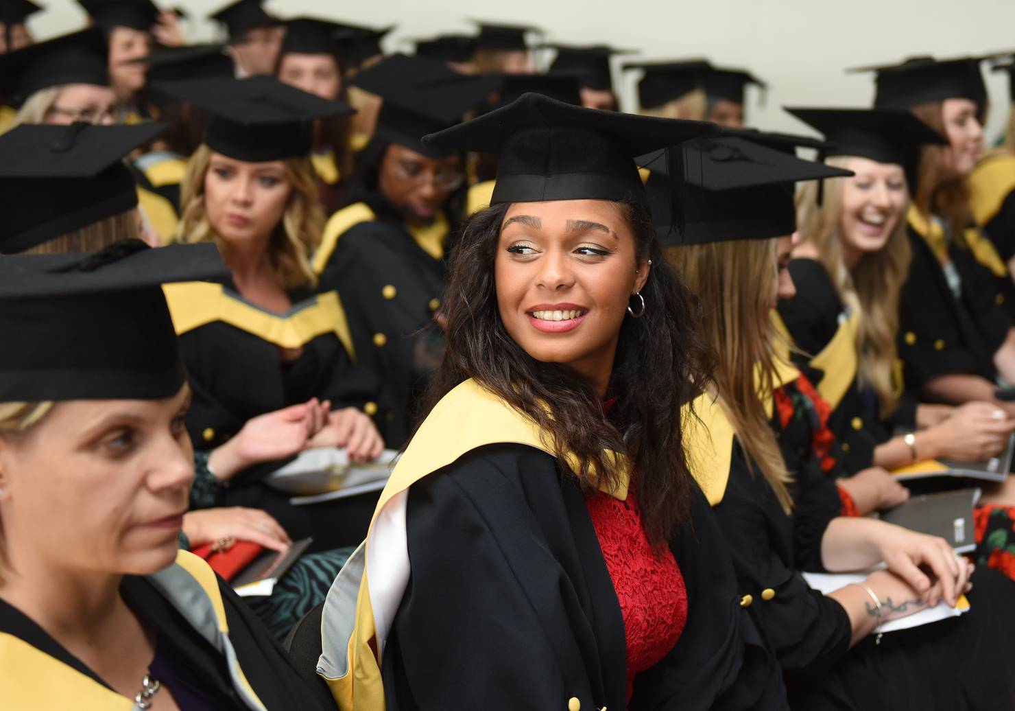 A student sitting with their peers in a graduation ceremony
