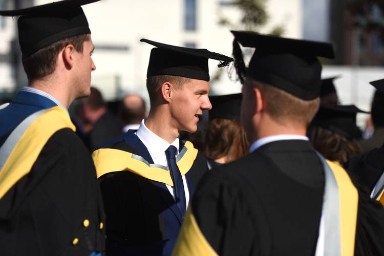 Students standing in their caps and gowns
