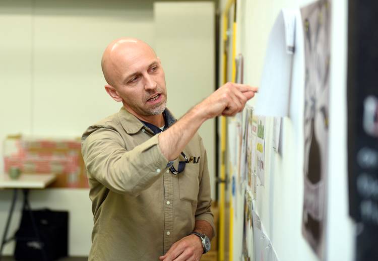 A lecturer pointing at work on a wall