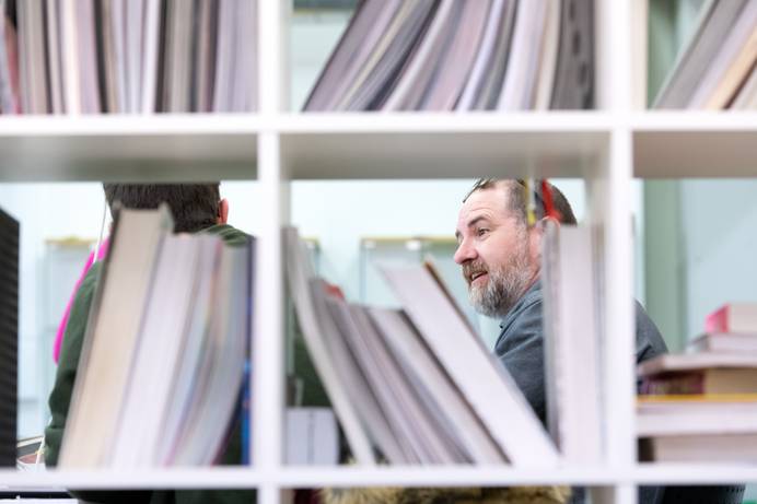 A view of a lecturer through a bookshelf