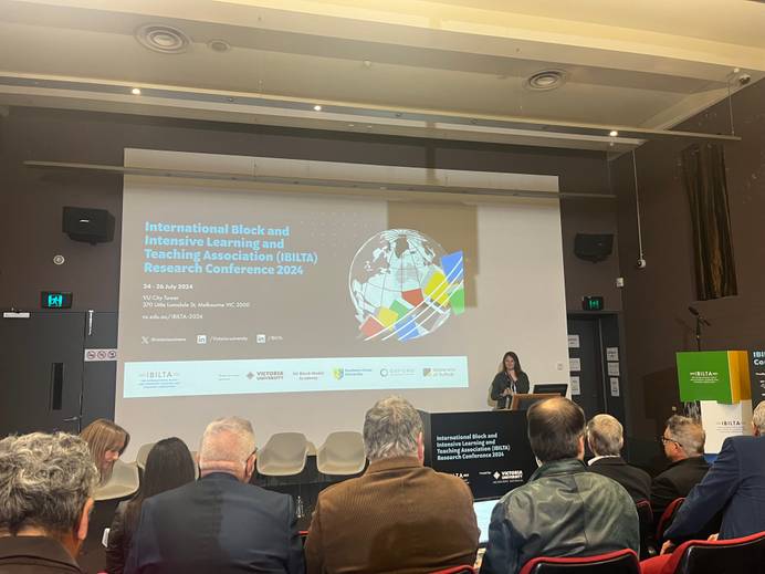 Dr Ellen Buck at the front of a lecture theatre addressing a room of conference delegates.