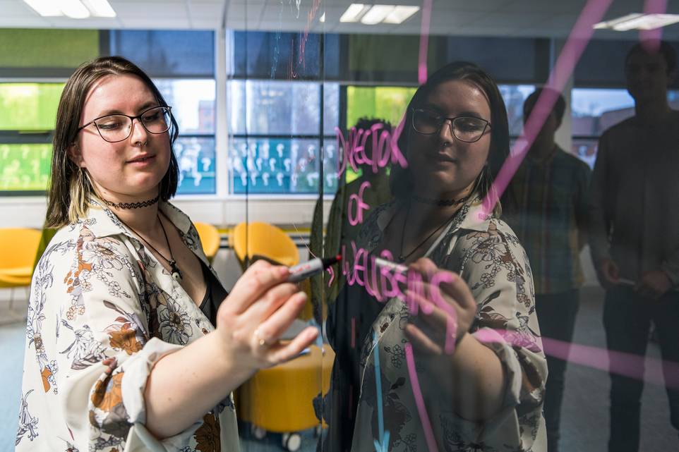 Close-up of student writing on a whiteboard