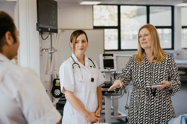 Lecturer talking to students on simulated ward