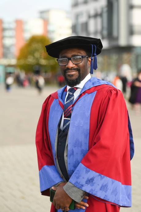 A graduate in a doctorate graduation gown and cap