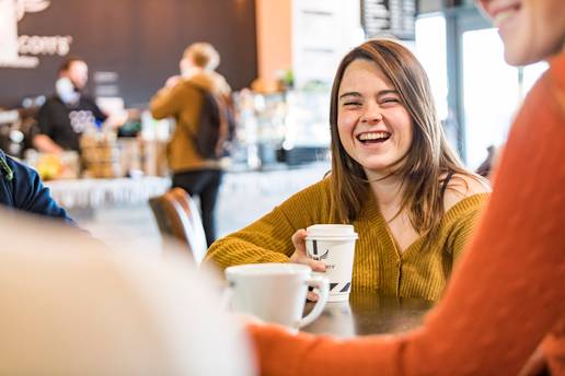 Close-up of a student sitting with a hot drink
