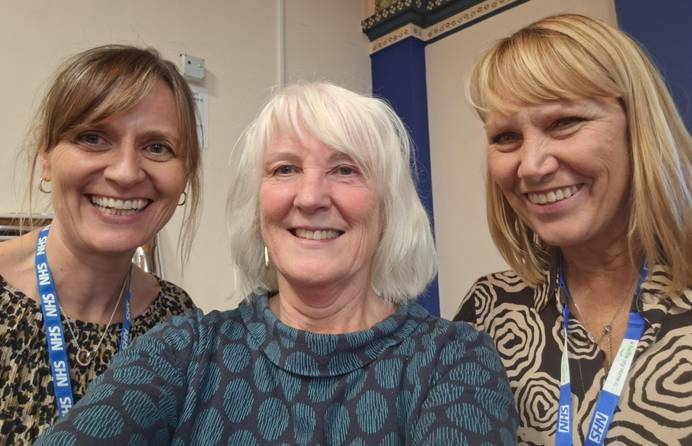 Three women together smiling after award win for one of them