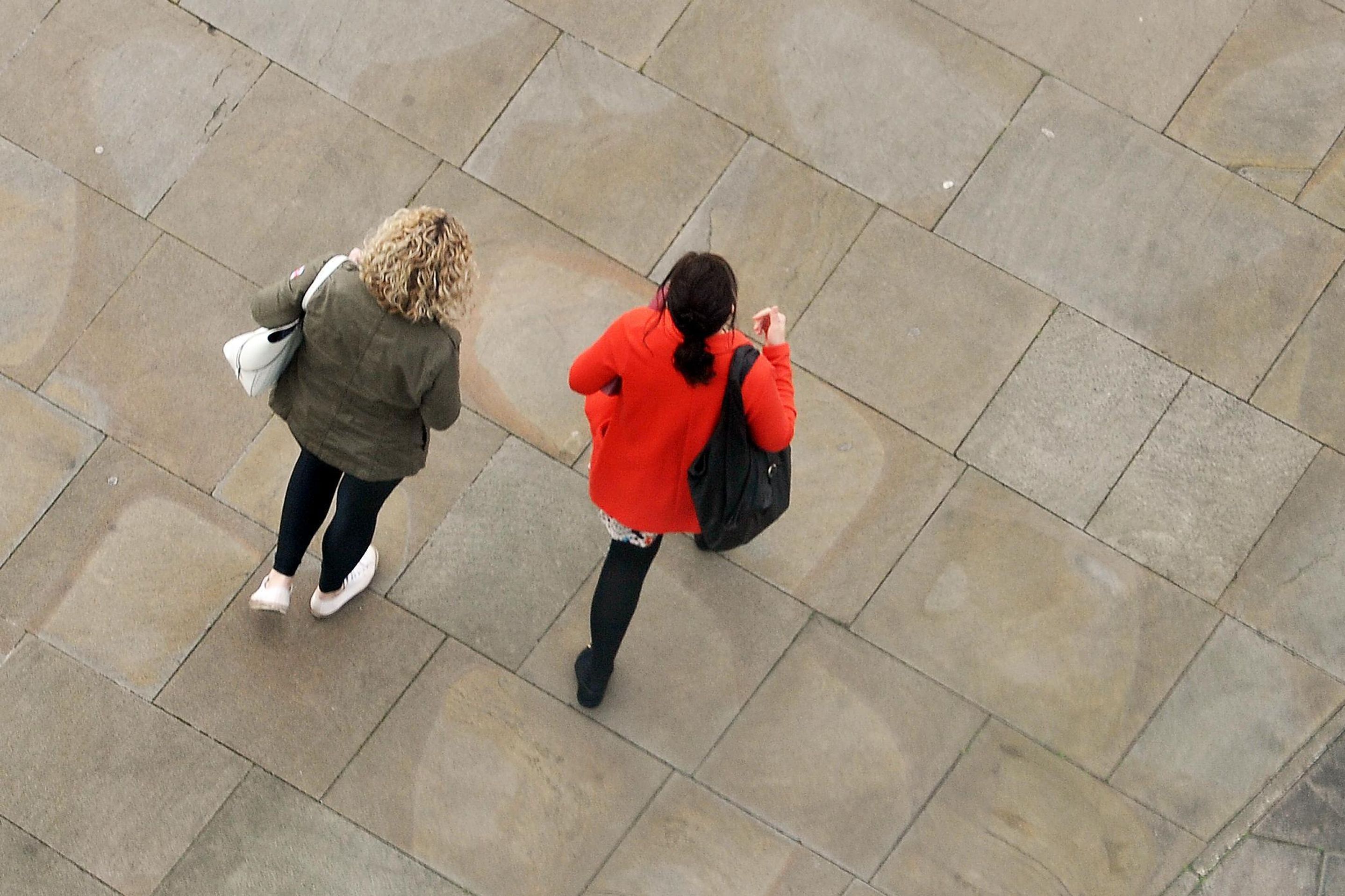 Two students walking on the waterfront plaza