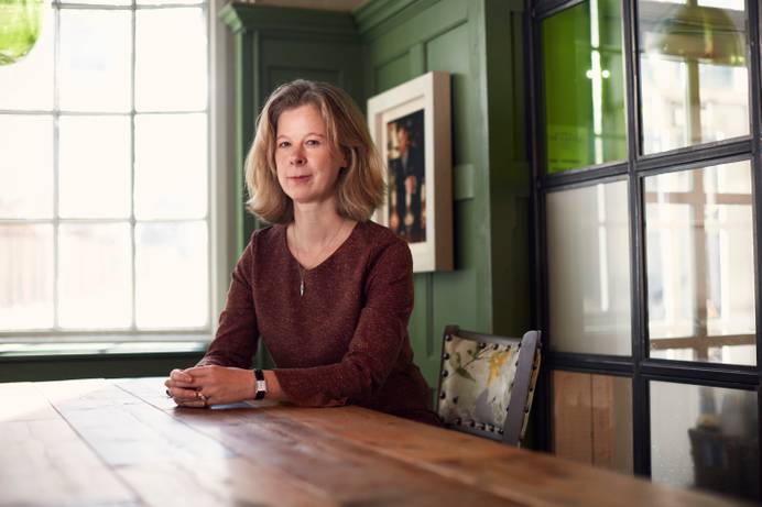 A photo of Professor Rachel Allen seated at a table. Prof Allen is the newly appointed Provost for the University.