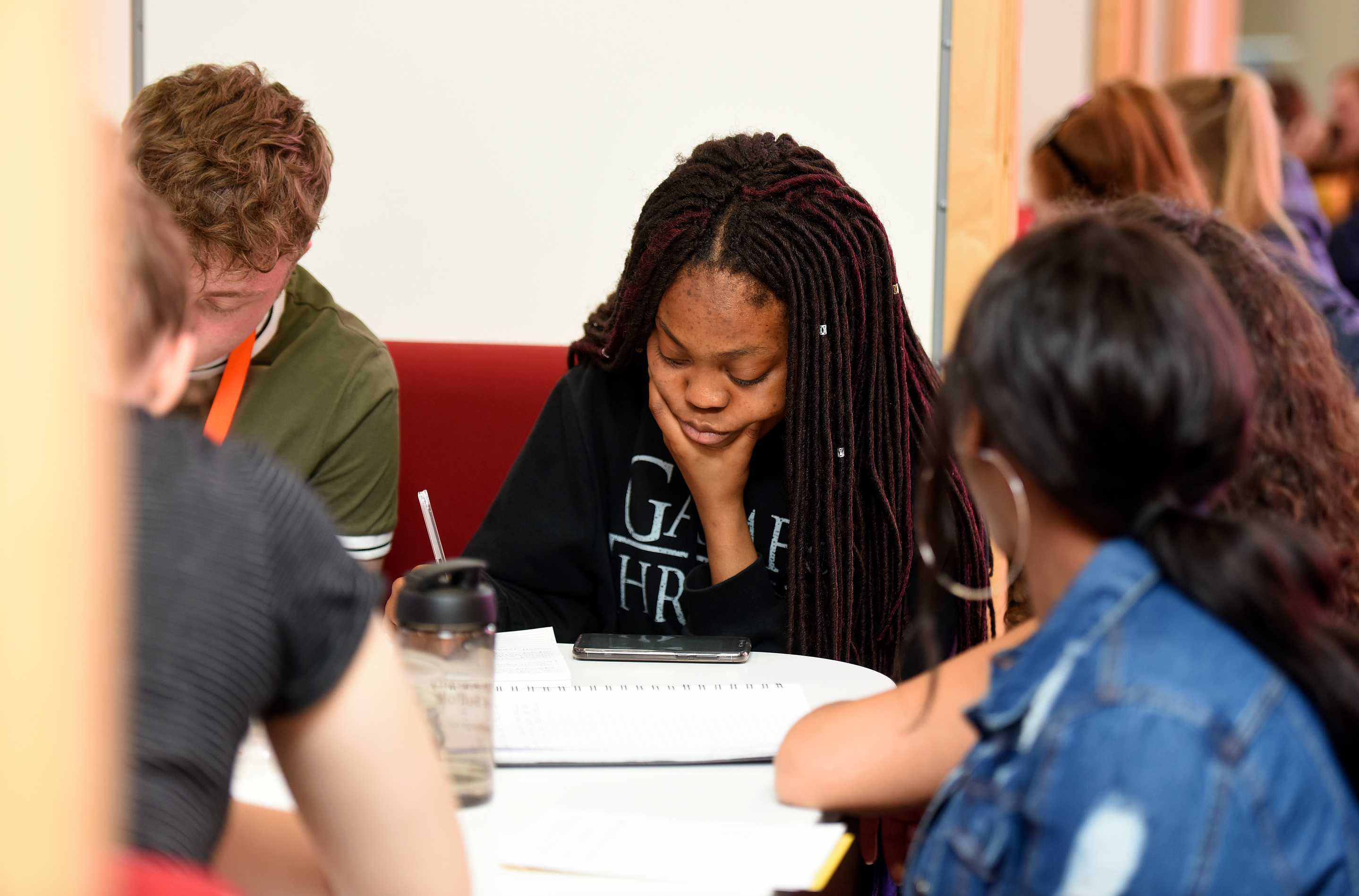 A student working with their peers in a study pod