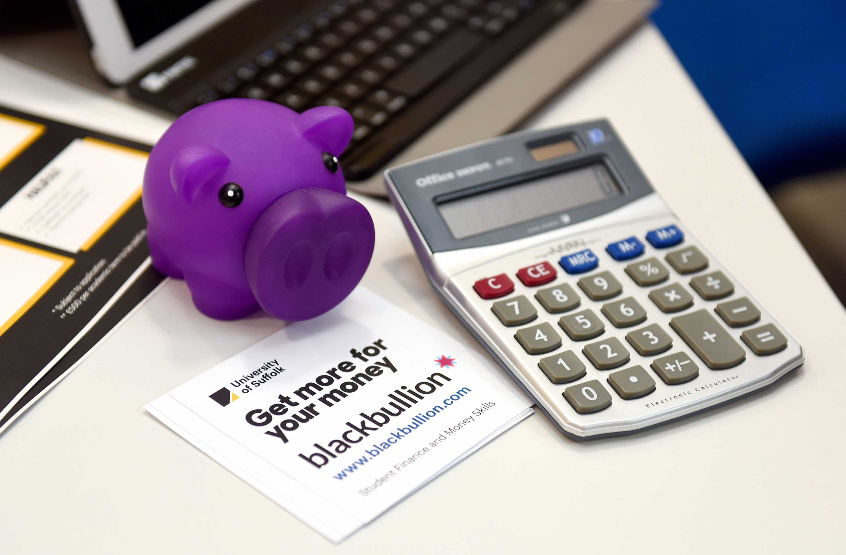 Calculator and laptop on a desk