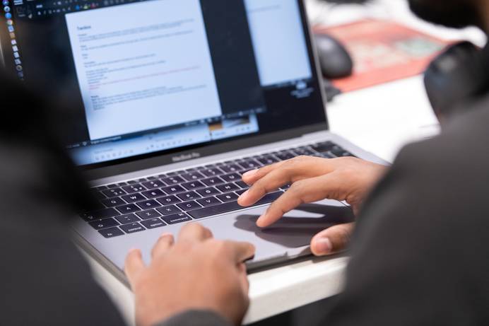Hands typing at a laptop computer