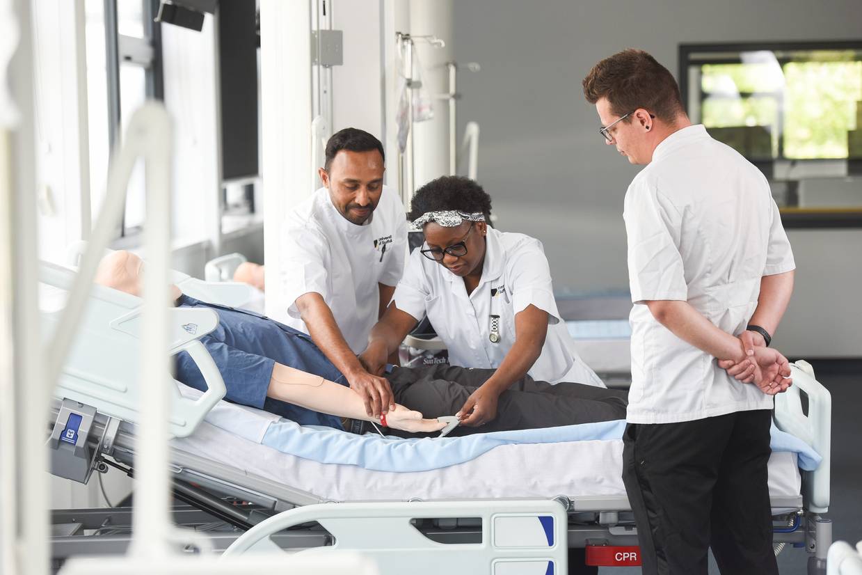 Students at a bedside in a stimulation ward