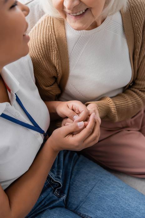 Social worker holding hands with senior woman