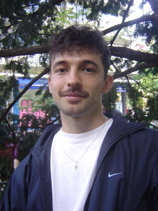 Image of a graduate wearing a white t-shirt and dark jacket