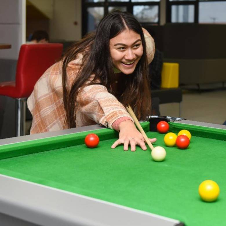 A student playing pool
