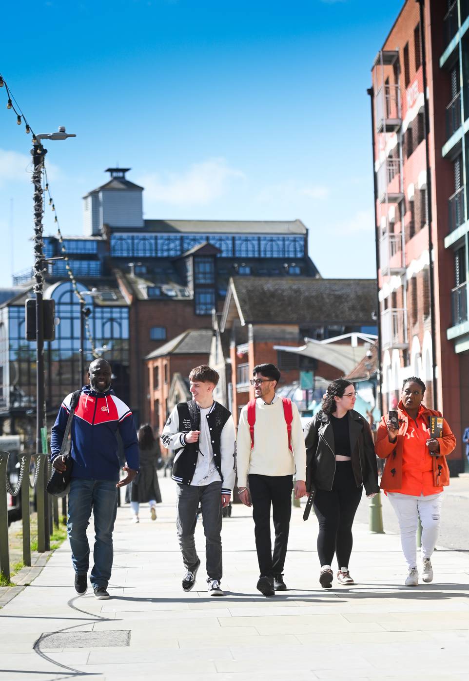 Students walking along the waterfront with buildings in the background