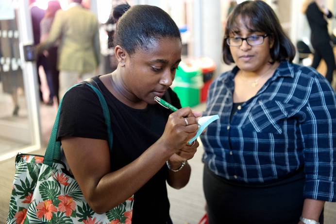 Someone writing on a post-it note