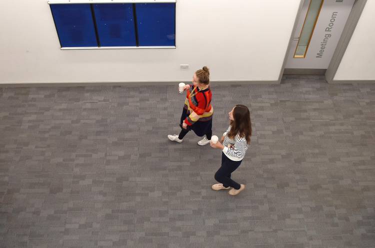 Two students walking together through a corridor