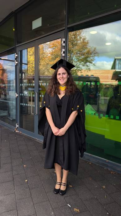 Graduate wearing a black graduation gown and hat